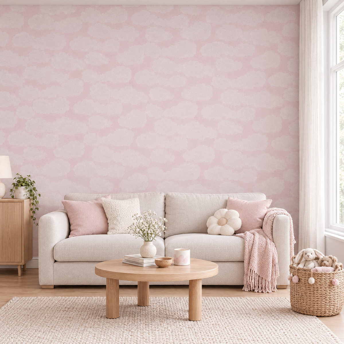 Salon familial avec papier peint rose pastel à nuages blanc-rose, canapé crème et table basse en bois