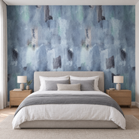 Chambre avec lit en lin blanc devant un papier peint aquarelle abstrait bleu et gris
