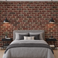 Chambre avec papier peint effet brique rouge et marron derrière le lit et suspensions noires