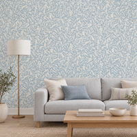 Salon avec papier peint feuillage bleu poudré sur fond crème