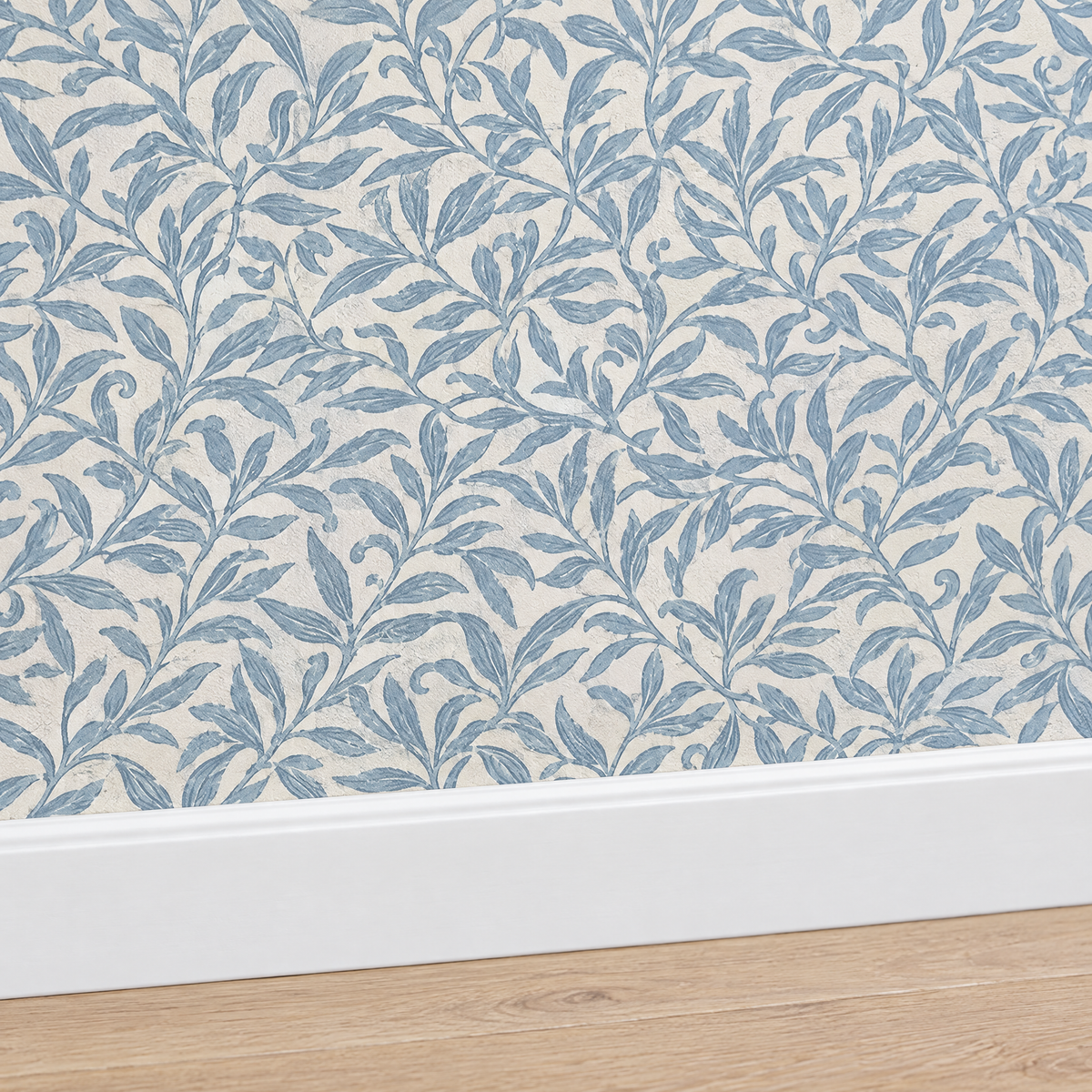 Gros plan plinthe blanche sous papier peint feuillage bleu poudré