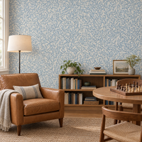 Salle de lecture avec papier peint feuillage bleu poudré sur fond crème