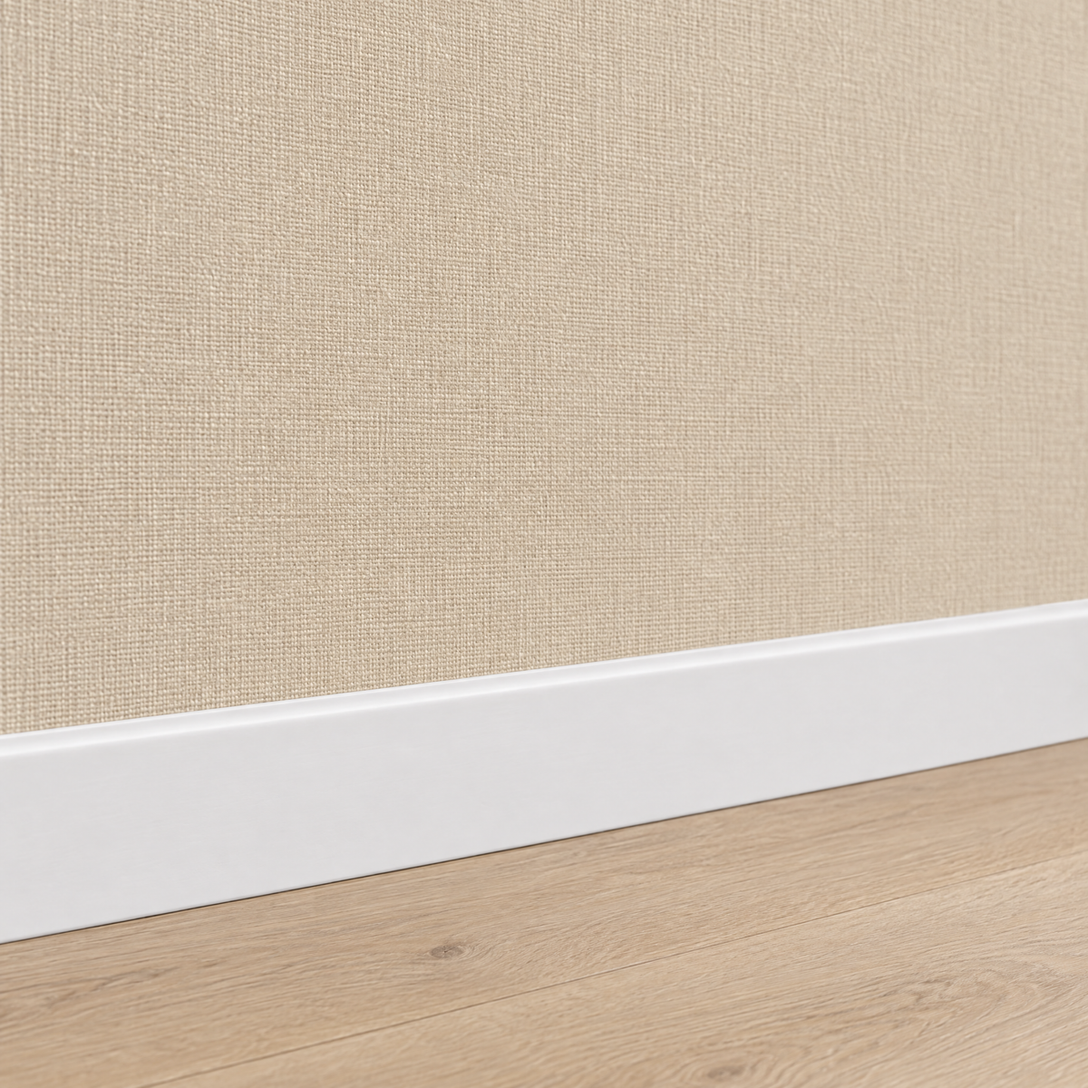 Gros plan sur le papier peint uni aspect lin beige au-dessus d'une plinthe blanche