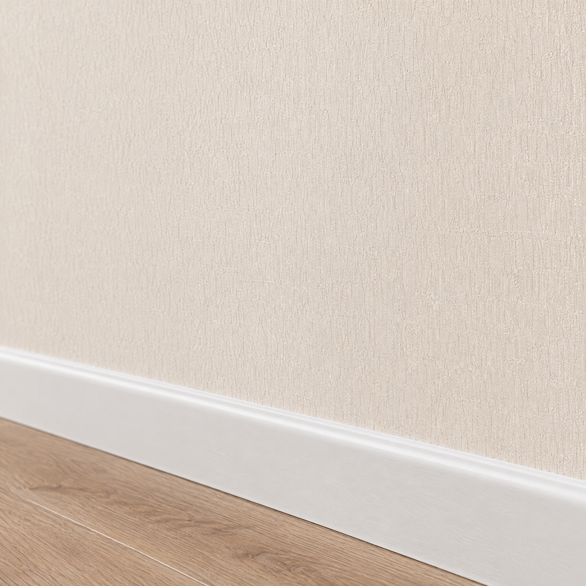 Gros plan sur la texture froissée du papier peint beige et argent au-dessus de la plinthe