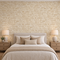Papier peint effet brique de pierre beige crème derrière une tête de lit en chambre