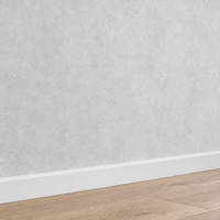 Papier peint uni effet béton gris clair, détail avec plinthe