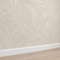 Papier peint feuillage tonal beige crème effet brillant, gros plan sur la plinthe